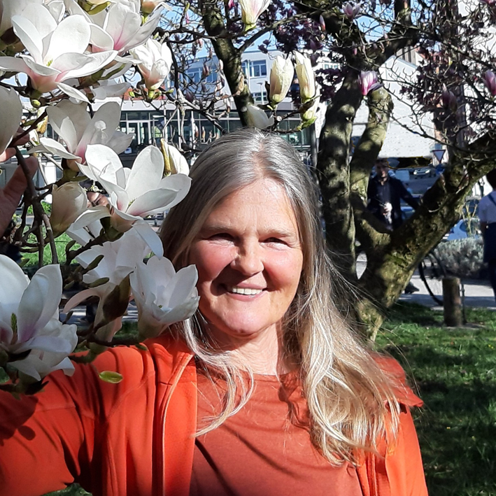 Portrait der lächelnden Therapeutin neben blühenden Magnolien